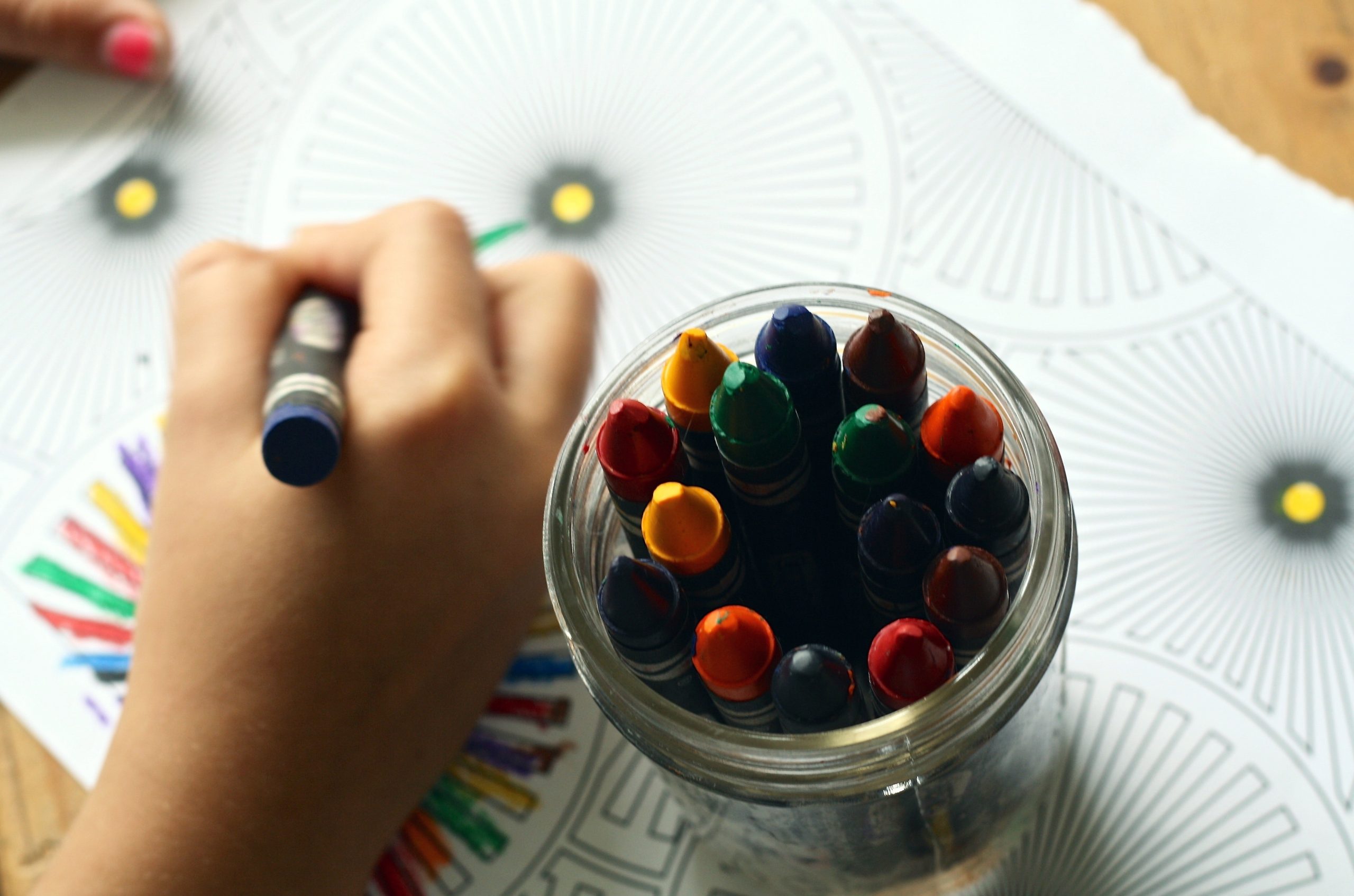 Image of child's hand drawing with crayons